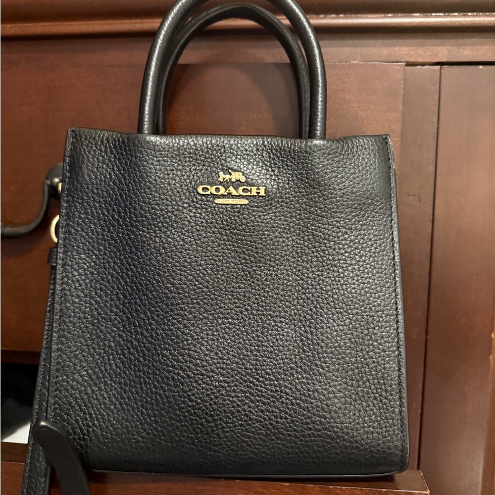 NWOT authentic Coach black pebble leather cross-body. Gold hardware and classic.